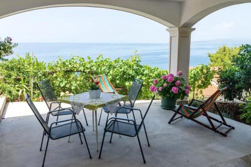 a table and chairs on a patio with the ocean at Apartments Villa Bella Vista in Gornji Dingač