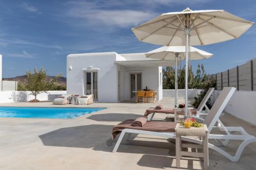 a patio with a chair and an umbrella and a pool at Naxian Lounge Villas in Naxos Chora
