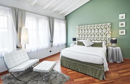 una camera con un letto bianco e una sedia di Villa Archi B&B a San Pietro in Cariano