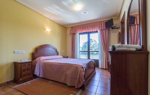 Hostal Restaurante O'Cadaval في Frades: غرفة نوم بسرير ونافذة كبيرة