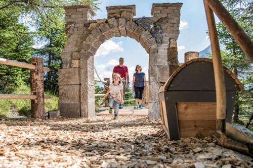 a woman and two children walking through an archway at Haus Fischer in Pettneu am Arlberg