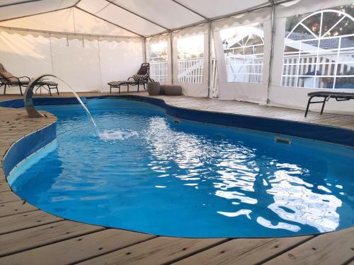 a swimming pool in a tent with a water fountain at Vanilla Grey in Had Nes