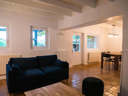una sala de estar con un sofá y una mesa en La Petite Maison, jardin et jacuzzi, proche de Lyon, en Charly