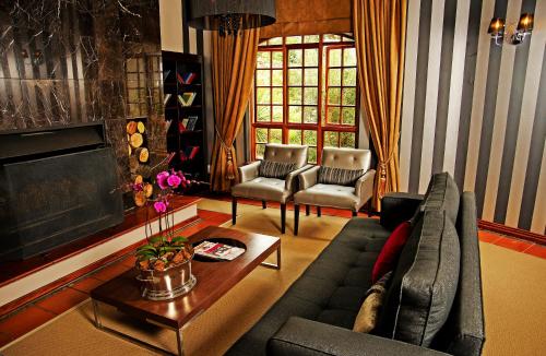 a living room with a couch and a table at Valley Lodge & Spa in Magaliesburg