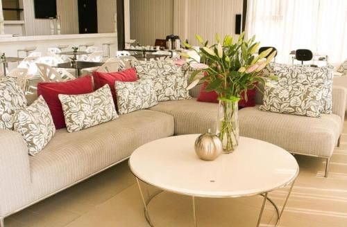a living room with couches and a table with a vase of flowers at Valley Lodge & Spa in Magaliesburg