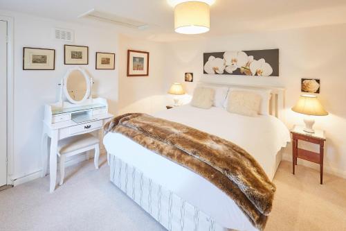 a bedroom with a bed and a vanity and a mirror at Host & Stay - Rose Cottage in Stokesley