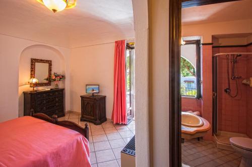 a bedroom with a bed and a tub and a sink at Hotel San Valentino Terme in Ischia