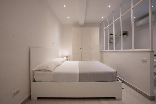 una camera bianca con letto e armadi bianchi di Casa Vacanze Santa Teresella 40 a Napoli