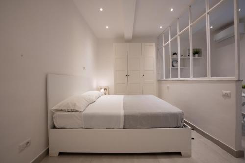 biała sypialnia z łóżkiem i białymi szafkami w obiekcie Casa Vacanze Santa Teresella 40 w mieście Neapol
