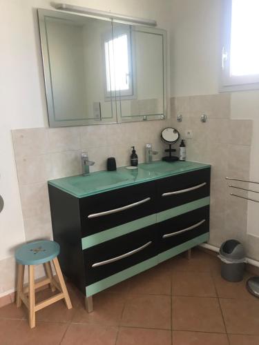 a bathroom with a sink and a mirror and a stool at Chambre en Ardèche du Sud in Saint-Remèze