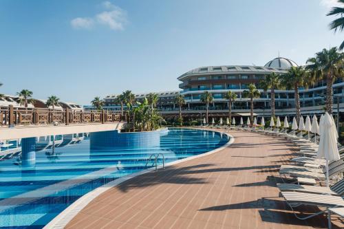 un complexe doté d'une piscine avec des chaises longues et des parasols dans l'établissement Tui Magic Life Jacaranda, à Sidé