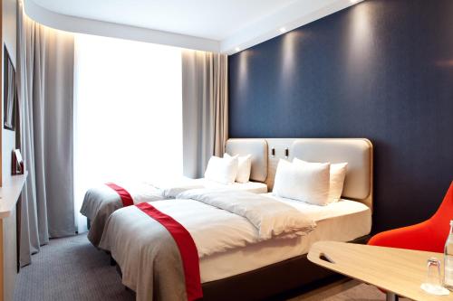 a bedroom with two beds and a large window at Holiday Inn Express Oberhausen by IHG in Oberhausen