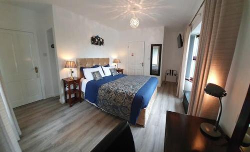 1 dormitorio con cama azul y edredón azul en Moyola River Cottage, en Magherafelt