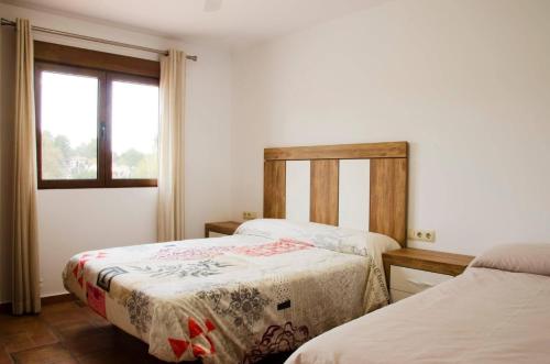 1 Schlafzimmer mit 2 Betten und einem Fenster in der Unterkunft Las Palmeras Casa Rural in Navarrés