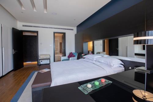 a bedroom with a large white bed and a table at The Abdali Boulevard Hotel in Amman