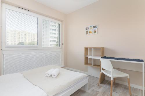- une chambre blanche avec un bureau, un lit et une chaise dans l'établissement Metro Wilanowska Comfortable Apartment, à Varsovie
