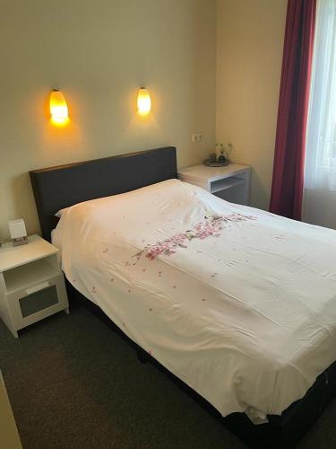 a bedroom with a large bed with flowers on it at Hotel Café Restaurant Snackbar Beerzerveld in Beerzerveld