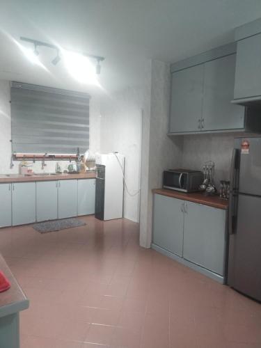 a kitchen with white cabinets and a stainless steel refrigerator at CMK APARTMEN MUTIARA TOWER 3 BEDROOM KOTA BHARU#Netflix in Kota Bharu