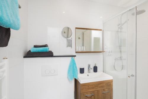 a white bathroom with a sink and a shower at B&B Resort Tremele in Dreumel