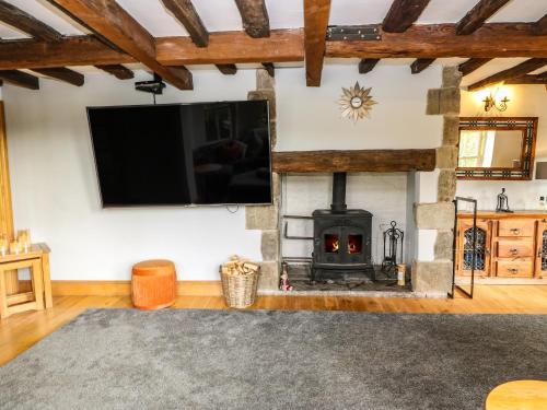 a living room with a fireplace and a flat screen tv at Belvedere Farm in Halifax