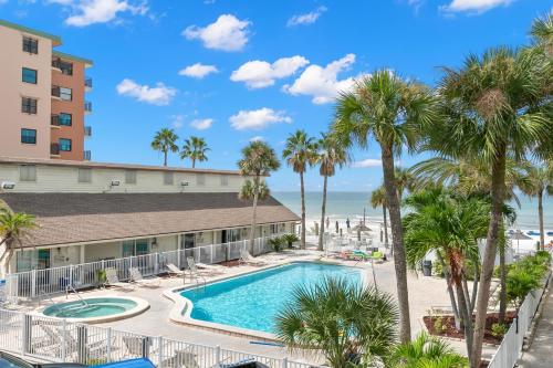 a view of the pool at the resort with palm trees and the ocean at Grand Shores West in St Pete Beach
