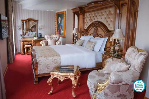 a bedroom with a bed and a couch and a chair at Prezident Palace Belgrade - Adults Only in Belgrade