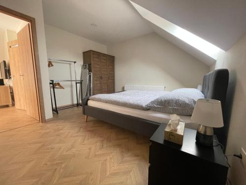 een slaapkamer met een bed en een bureau met een lamp bij Koliko apartman in Mohács