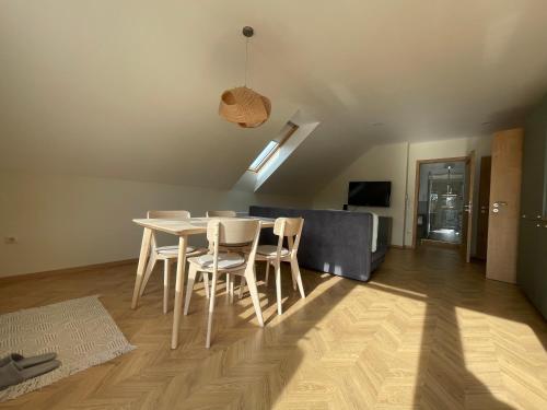 a dining room and living room with a table and chairs at Koliko apartman in Mohács