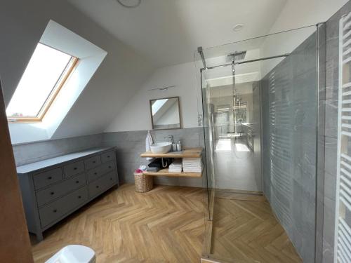 a bathroom with a glass shower and a sink at Koliko apartman in Mohács