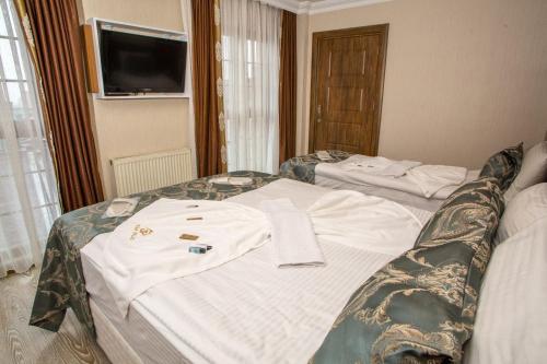 a hotel room with two beds with a t shirt on it at Bursa Palas Hotel in Bursa