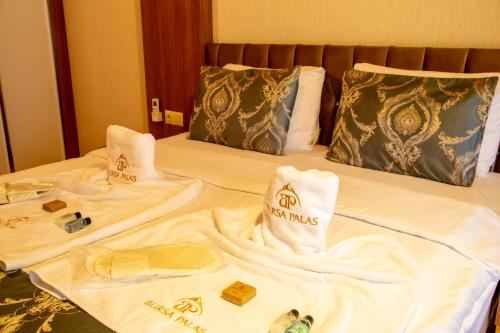 a bed with white towels and pillows on it at Bursa Palas Hotel in Bursa