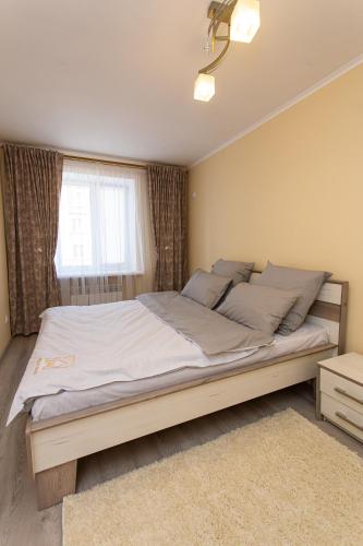 a bedroom with a large bed with a window at Центр. Острозького. Цум. 2 кімнати in Ternopilʼ