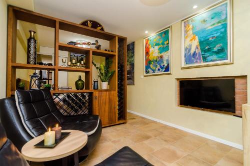 a living room with a black leather chair and a fireplace at Apartment City Getaway in Dubrovnik