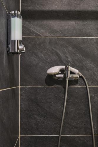un pommeau de douche fixé à un mur carrelé dans l'établissement Calme en centre ville, appartement 50m de la Place Carnot, à Carcassonne
