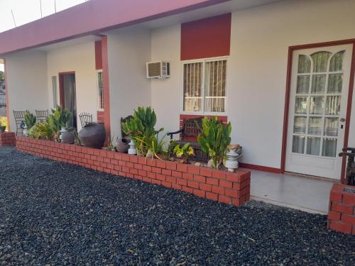 a house with a brick retaining wall in front of it at Doroteo's Transient House in Calingcuan