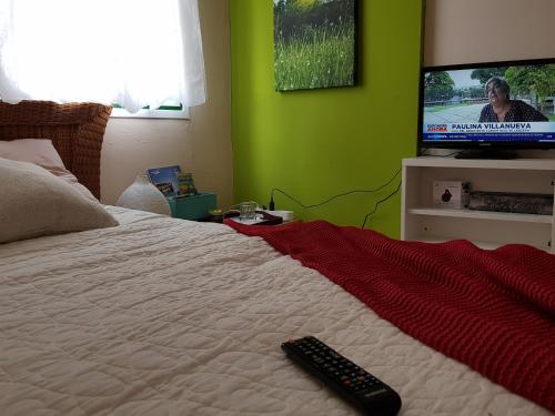 a bedroom with a bed with a remote control on it at THE POPPIES Guest House - 100m Ocean - Private Spaces in Candelaria