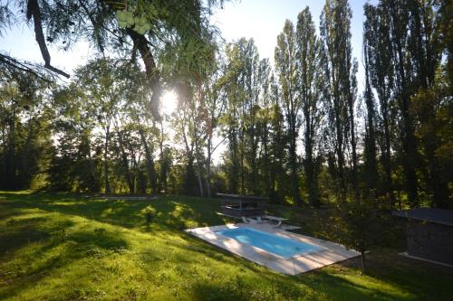 a swimming pool in a field with trees at Le Domaine de Moroges in Moroges