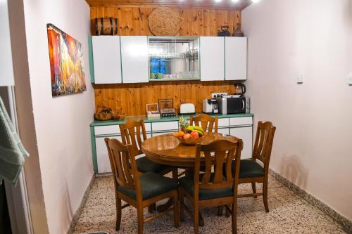 a kitchen with a wooden table with chairs and a dining room at Sophias Cottage in Askas