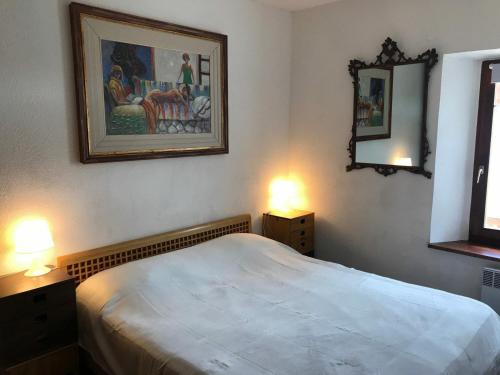 1 dormitorio con 1 cama, 2 lámparas y una pintura en Appartement Montgenèvre, 2 pièces, 6 personnes - FR-1-445-119, en Montgenèvre