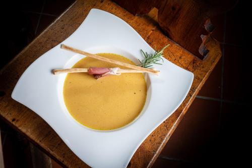 a white plate with a bowl of soup on a wooden tray at Naturhotel Hüttenwirt im Grossarltal in Hüttschlag