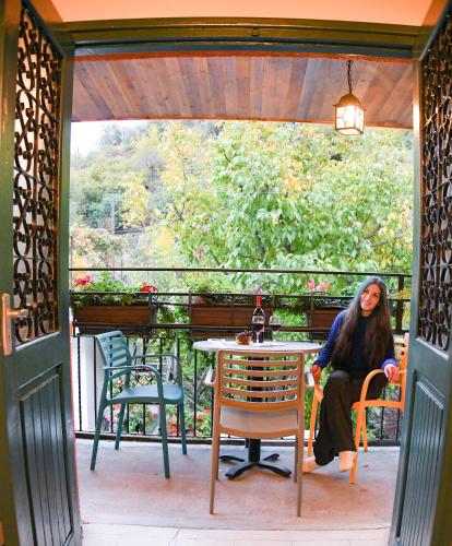 a woman sitting at a table on a patio at Sophias Cottage in Askas