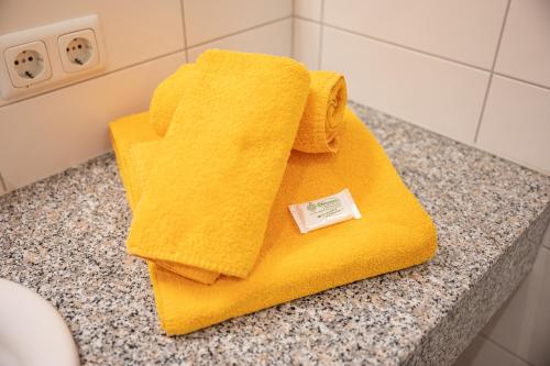 a yellow towel sitting on a counter in a bathroom at Naturhotel Hüttenwirt im Grossarltal in Hüttschlag
