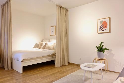 biała sypialnia z łóżkiem i stołem w obiekcie NEU - gemütliches und modernes Apartment mit Stellplatz w Koblencji