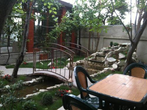 a table and chairs in a garden with a pond at Sanata in Tbilisi City