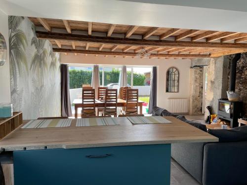 een keuken met een tafel en een woonkamer bij Charmante maison à deux pas de la mer in Gouville-sur-Mer