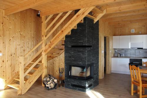 - un salon avec une cheminée et un escalier dans l'établissement Domek Pod Wierzbą, à Sikorzyno