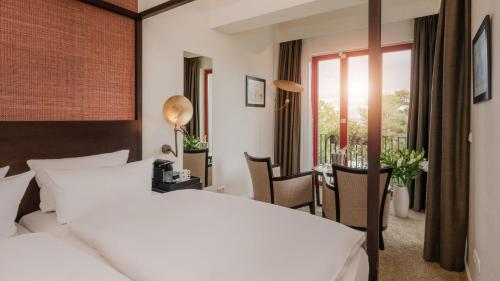 a hotel room with a bed and a table and chairs at Strandhotel Heringsdorf in Heringsdorf
