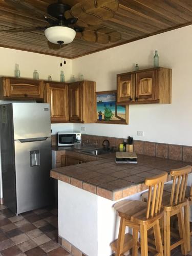 a kitchen with a stainless steel refrigerator and wooden cabinets at Hotel Los Cielos Del Caribe in Cahuita
