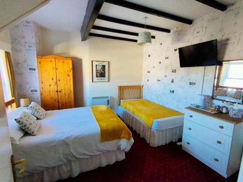 a bedroom with two beds and a flat screen tv at Bluestones in Keswick