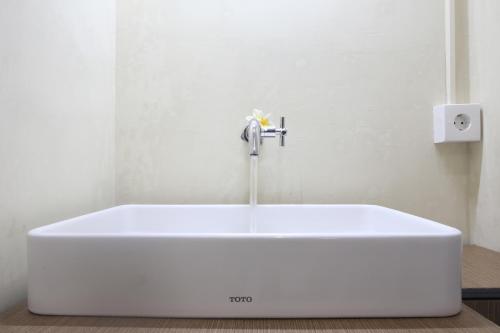 a white bath tub with a faucet in a bathroom at Aru House Ubud in Ubud